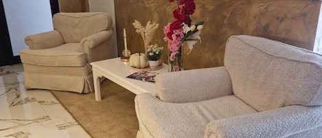 A hotel lobby with a sofa, armchair, and a coffee table.