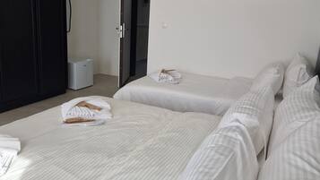 Habitación de hotel con dos camas, un cuadro de un tigre en la pared y un armario.