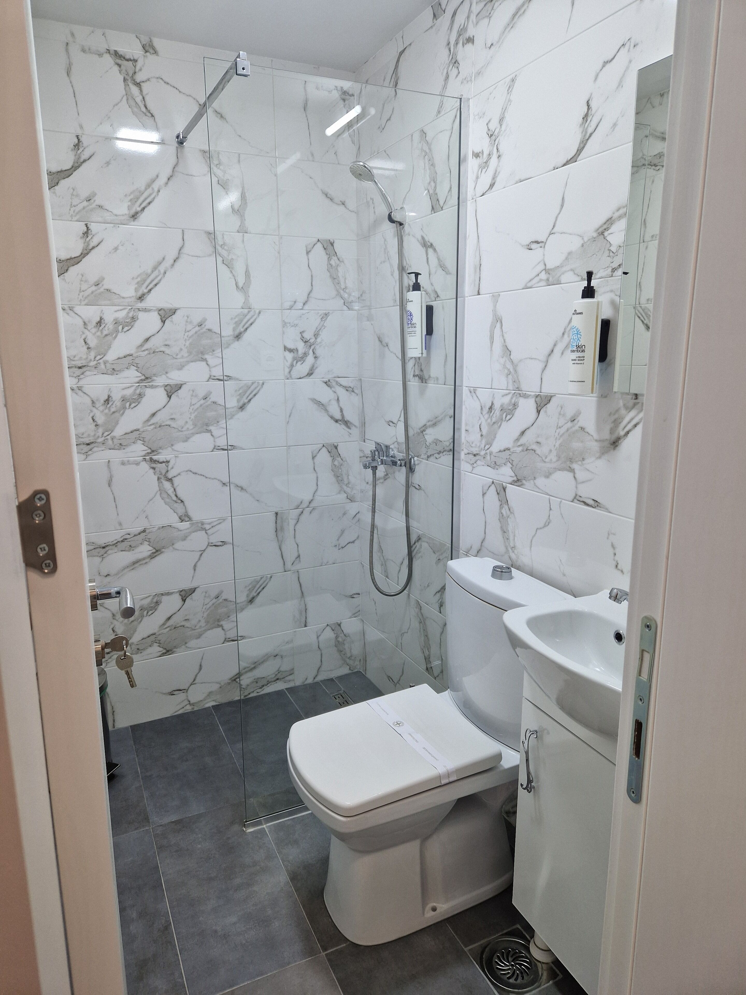 Ein Badezimmer mit Dusche, Toilette und Waschbecken.
