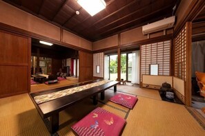 Ein traditioneller japanischer Raum mit Tatami-Boden, einem niedrigen Tisch und Schiebetüren.
