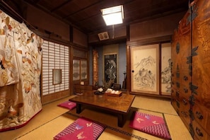 Ein traditioneller japanischer Raum mit Tatami-Boden, einem niedrigen Tisch und gleitenden Türen.
