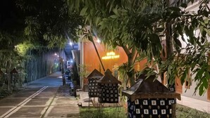 Un chemin bordé de lanternes décoratives et un bâtiment dont l’enseigne est illuminée.