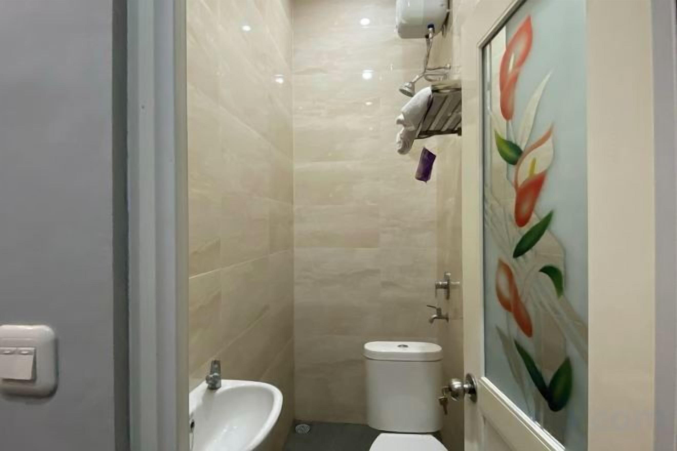 A bathroom with a sink, toilet, and a shower area.