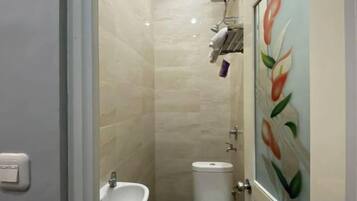 A bathroom with a sink, toilet, and a shower area.