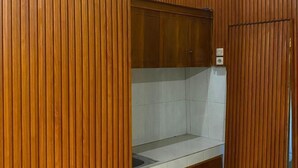 Une salle de bain avec un lambris en bois, une zone de douche carrelée et une porte en bois.