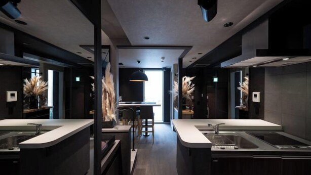 A modern kitchen with two islands, a dining area, and a view of the city. - Trive Ozone (Nagoya)