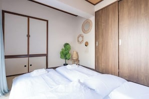 A hotel room with a bed, a wardrobe, and a small plant. - Terra APT - OOJI (Tokyo)