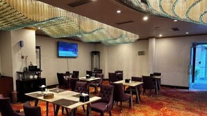 A conference room with tables and chairs, a projector screen, and a decorative ceiling. - Huadu Hotel (Kathmandu)
