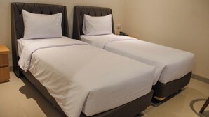 A hotel room with two single beds, a bedside table, and a telephone. - Lakeside Tell Cikarang (Serang Baru)