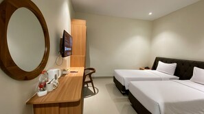 A hotel room with two beds, a desk with a chair, a large mirror, and a television mounted on the wall. - Lakeside Tell Cikarang (Serang Baru)