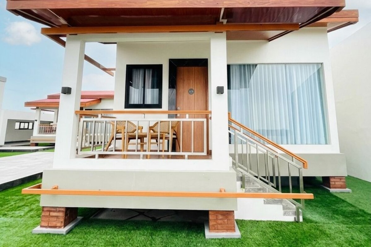 Un bâtiment moderne à deux étages, doté d’un balcon, d’un escalier et d’une porte.
