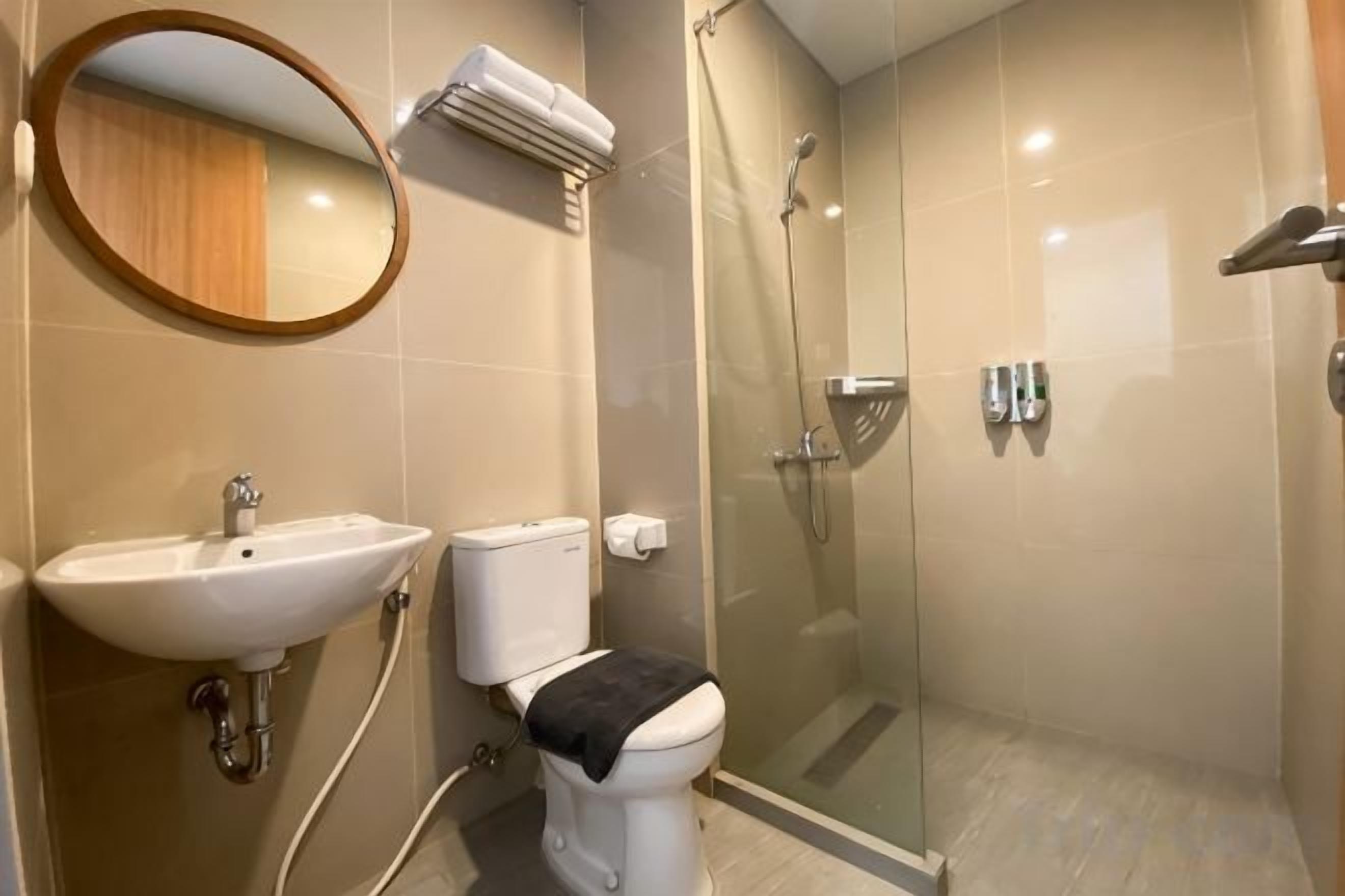 A bathroom with a sink, toilet, and glass-enclosed shower.