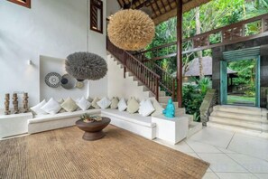 A modern interior with a staircase, a seating area, and a view of the outdoors. - VillaJewel Bali (Bali)