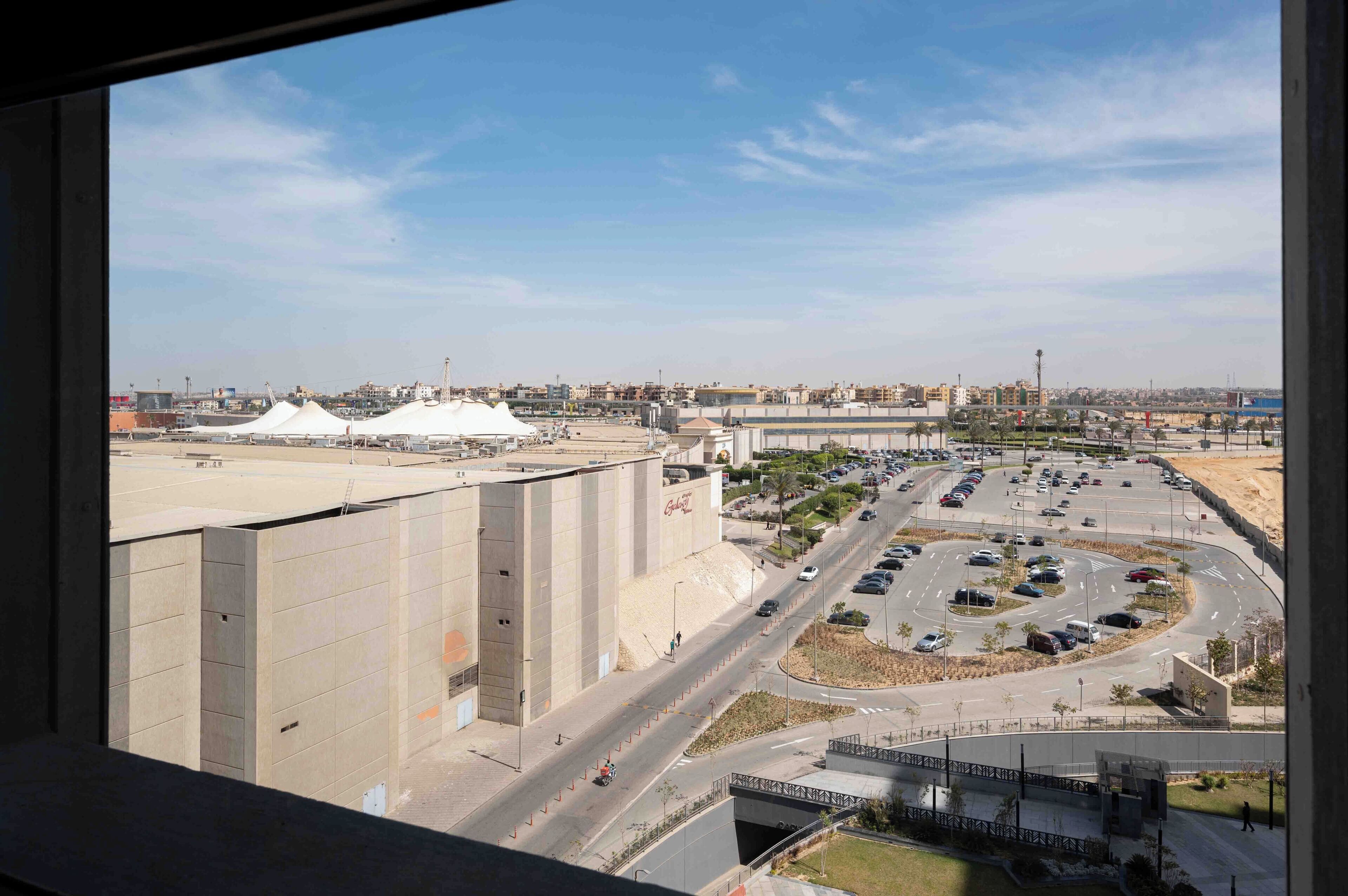 A view of a large industrial area with multiple buildings, a parking lot, and a road network.