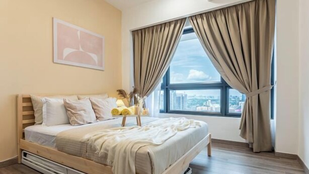 Une chambre à coucher avec un lit, une fenêtre avec des rideaux, une vue sur la ville et un tableau au mur.