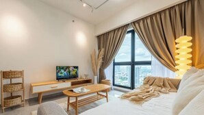 Une chambre moderne avec un lit, une télévision, un bureau en bois et une grande fenêtre avec des rideaux.
