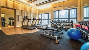Une salle de sport moderne équipée de tapis de course, d’haltères et de ballons d’exercice.
