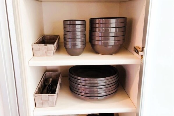 A storage cabinet with shelves holding various kitchenware items. - Nikko Vacation House (Nikko)