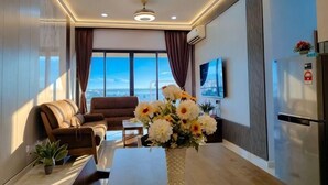 Una sala de estar moderna con un sofá, una mesa de centro, un jarrón de flores y un ventanal con vistas.