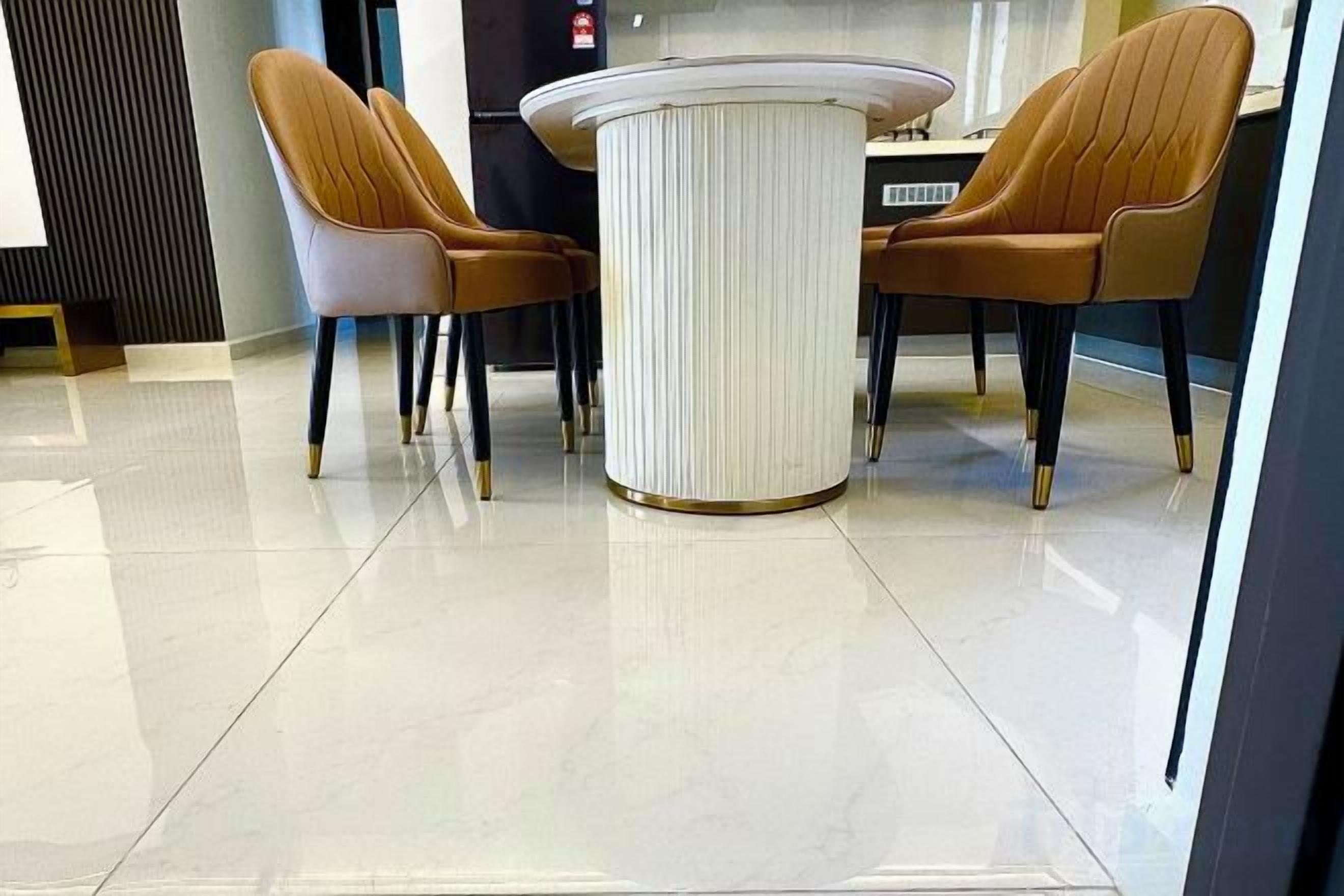 Un espace repas moderne avec une table ronde et deux chaises marron.