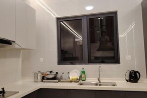 A modern kitchen with a window, a sink, and a countertop with various items.