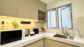 A modern kitchen with a microwave, toaster, kettle, and a window with blinds. - D'Kayangan, Setia Ecohill Semenyih Serenity Suite (Semenyih)