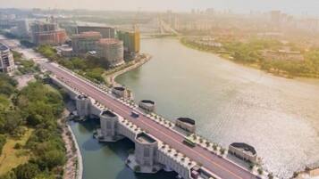 A river with a bridge, buildings, and greenery.