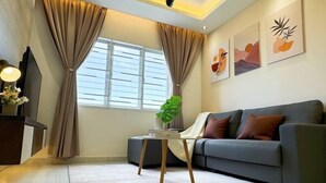 A modern living room with a grey sofa, a small side table, and a large window with curtains. - D'Kayangan, Setia Ecohill Semenyih Serenity Suite (Semenyih)