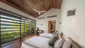 A bedroom with a large bed, a ceiling fan, a sliding glass door, and a view of greenery. - Sava Villa 2 Villa Amarelo (Takua Thung)