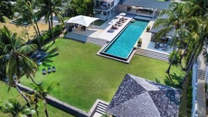 A large swimming pool with a sun terrace, surrounded by palm trees and a well-maintained lawn. - Sava Villa 2 Villa Amarelo (Takua Thung)
