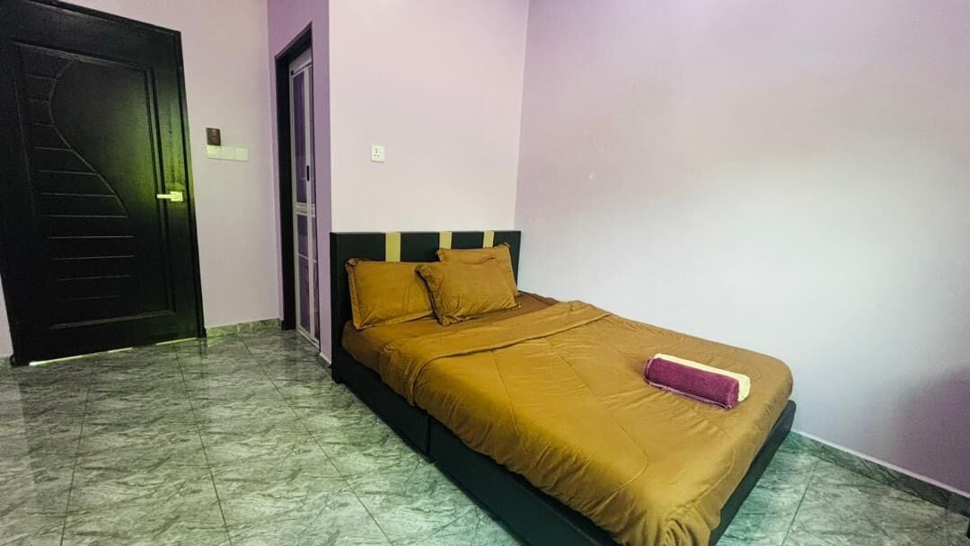A bedroom with a bed, a door, and a wall.