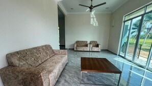 A spacious living room with a marble floor, a sofa, two armchairs, and a coffee table. - Capital O 91227 Chalet D'bendang Mak Teh (Pendang)
