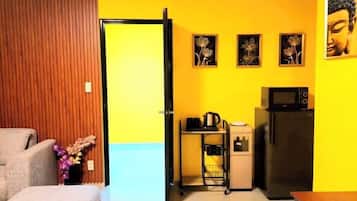 A compact living space with a kitchenette, a dining area, and a door leading to another room.