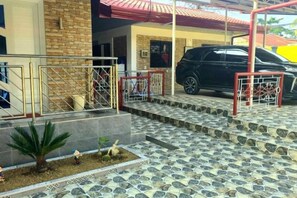 A building entrance with a staircase, a vehicle, and a gated area. - Jenessa's Executive-Suite near Lanuza Surf Bay (Madrid)