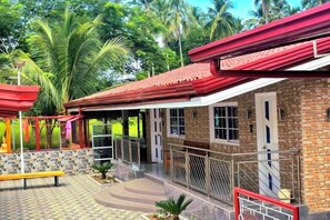 A building with a red roof, a covered porch, and a brick exterior. - Jenessa's Executive-Suite near Lanuza Surf Bay (Madrid)