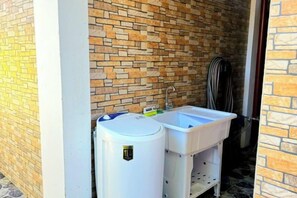 A bathroom with a brick wall, a white sink, and a white toilet. - Jenessa's Executive-Suite near Lanuza Surf Bay (Madrid)
