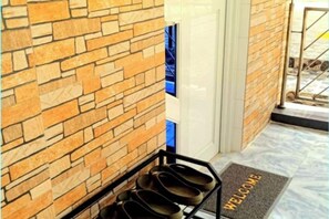 A brick wall, a shoe rack, and a welcome mat. - Jenessa's Executive-Suite near Lanuza Surf Bay (Madrid)