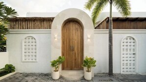 A building entrance with a wooden door, white walls, and potted plants. - Brand New Villa 2Br with Private Pool Near Seminyak by BaliSuperHost (Bali)