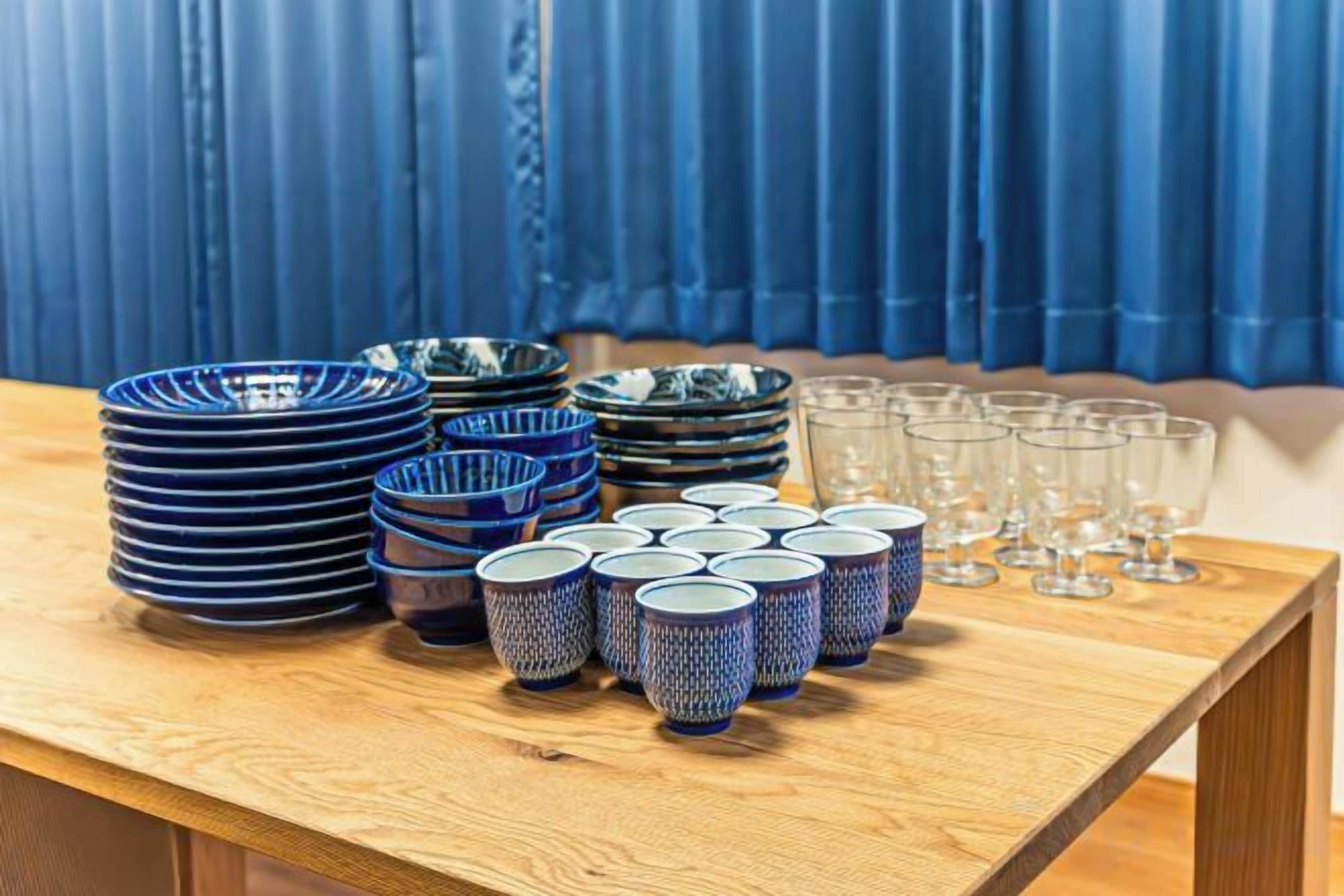A table with stacked bowls and cups, and empty glasses.