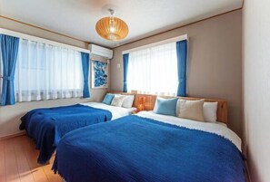 A hotel room with two beds, a wooden headboard, a ceiling light, and a window with curtains. - Third Place Tokyo - Aoto - (Tokyo)