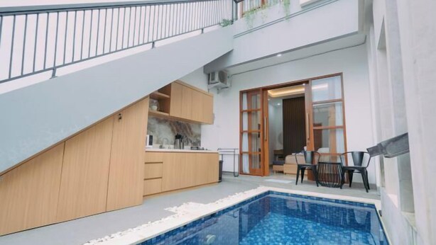 A modern apartment with a kitchen, dining area, and a small pool. - The Lavana Nakula Villa Kuta Sunset (Bali)