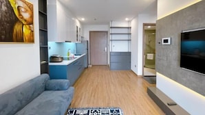Een modern interieur met een bank, keuken en televisie.