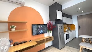 Een moderne keuken met een ingebouwde televisie, een koelkast en een eethoek met een tafel en stoelen.
