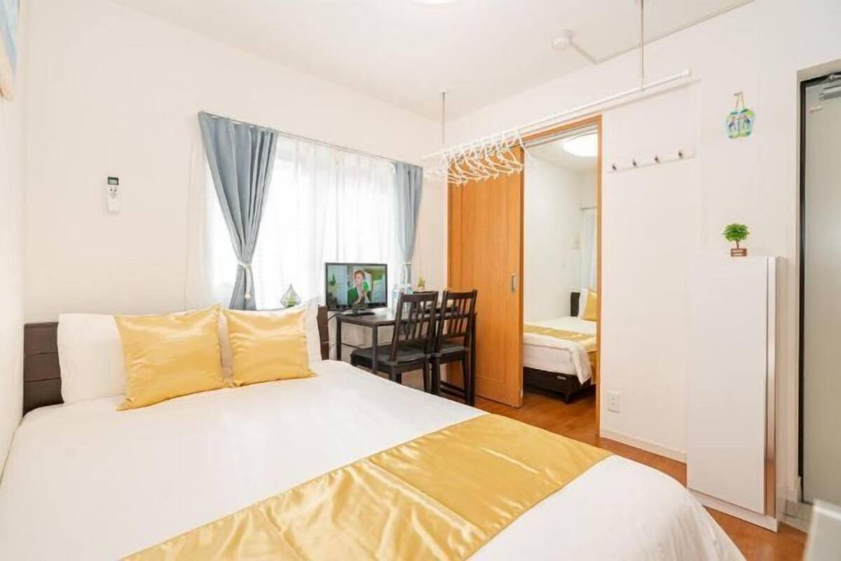A hotel room with a bed, a desk, and a chair.