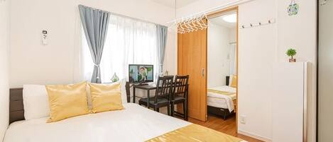 A hotel room with a bed, a desk, and a chair.