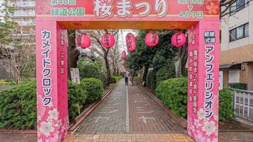 A pathway leading to a building entrance with a pink archway and floral decorations.