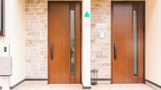A set of wooden doors with glass panels, set in a room with stone wall accents and a tiled floor. - youmeiyado kohama (Osaka)