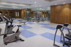 A gym with various exercise equipment, a mirrored wall, and a checkered floor. - MCollection - Private Rooms in Historic Manila Chinatown (Manila)