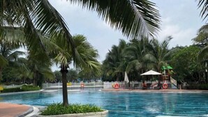 A swimming pool surrounded by palm trees and a white fence. - Alex'housing Vinhome D'capitale luxury apartment (Hanoi)