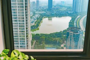 Un edificio alto con vistas a un lago y vegetación circundante.